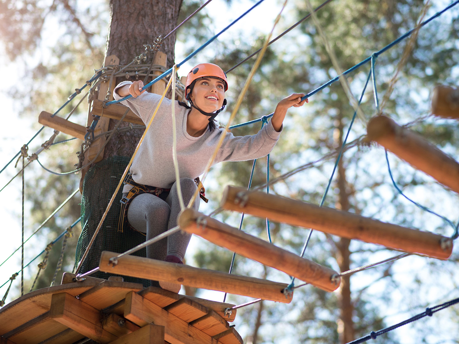 Woman walking on a rope course bridge