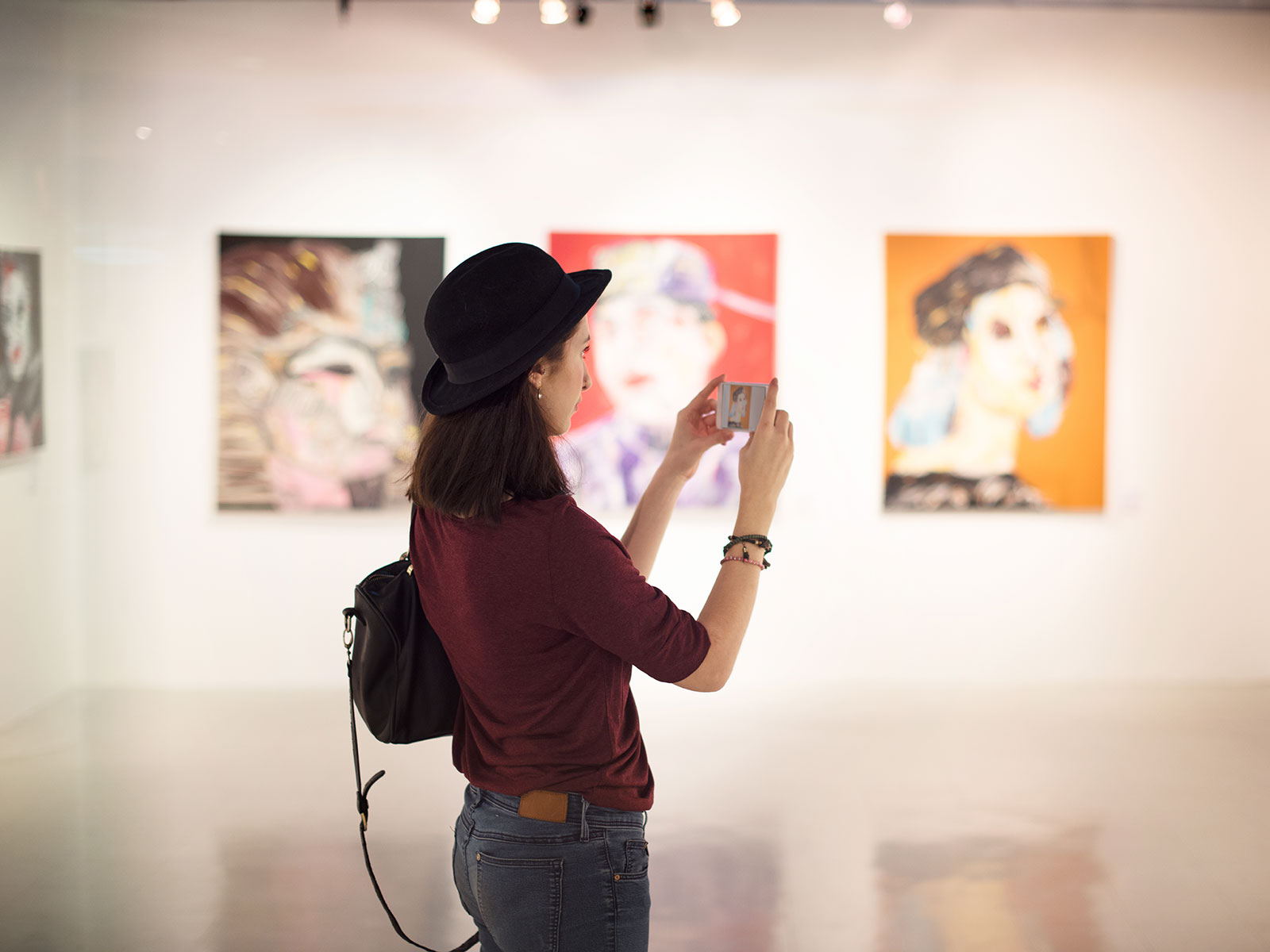 Woman taking a picture in an art gallery